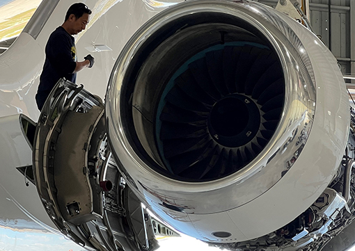 Aircraft mechanic looking at a jet engine