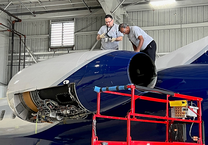 two airplane mechanics inspecting a private jet