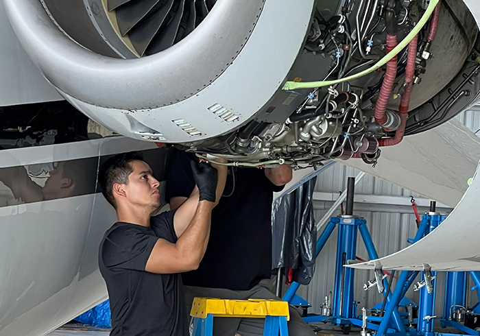 two aircraft mechanics working on an aircraft