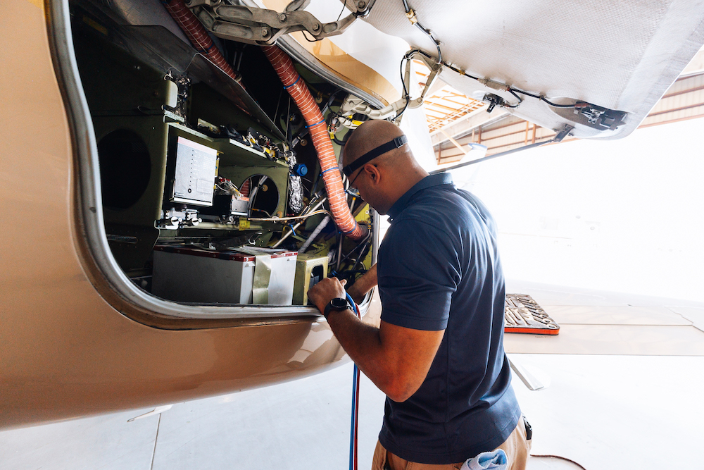A JetRx mechanic performing scheduled maintenance on a private jet